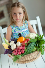 Beautiful little girl with basket vegetables 