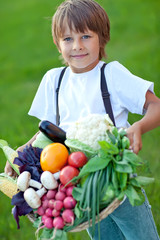 Happy little boy with fresh vegetables 