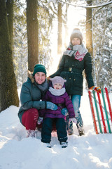 Cheerful family relaxing in the winter forest