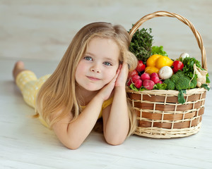 Beautiful little girl with basket vegetables 