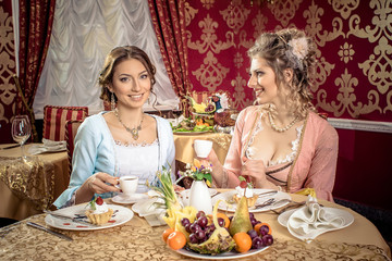 Girls in vintage dresses in the restaurant.  Retro Women Portrait. Romantic Beauty.Vintage Styled. Communication between two girls in the restaurant.