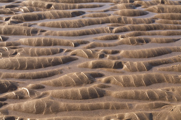 Tidal Patterns. A flat beach and a long tide leaves rippling patterns in the sand.