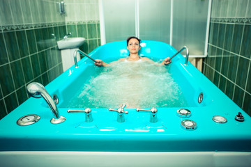 A girl and a hydromassage. She receives medical treatments for relaxation.