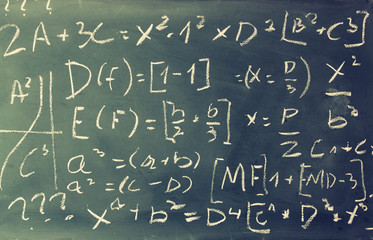 side view of math formulas and calculation written over chalkboard. selective focus.
