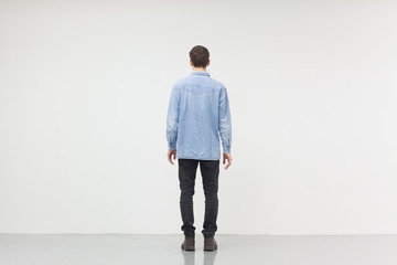 Man standing in front of a white wall, concept of thinking, making ideas