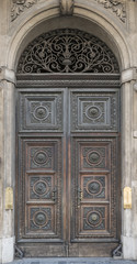 Old wooden door with arch with the bell