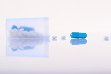 Fototapeta premium Pills falling out from open container. 