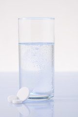 Glass of water mixed with pill.