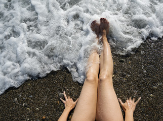 Female feet on the seashore