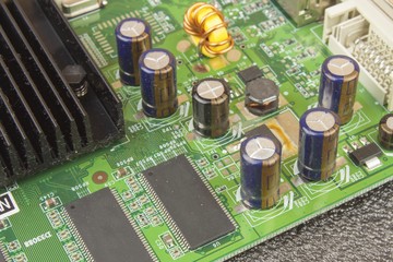 A dusty green computer component. Detail of a dusty computer mainboard. Electronic components on...