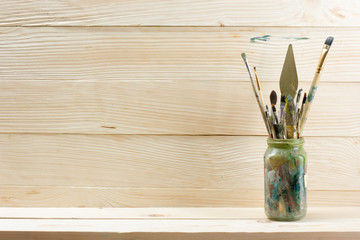 Artistic, artist, art. Used artist paintbrushes mastehin on wood background. 
