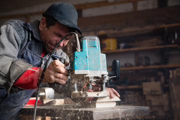 Carpenter milling machine processes the wood element