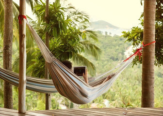 man lying in a hammock freelancer and running, beautiful mountai