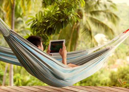 man lying in a hammock freelancer and running, beautiful mountai