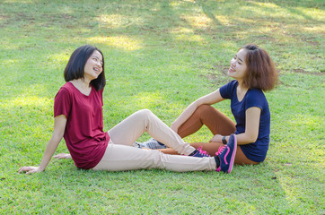 Asian girls sitting on grass field after exercise