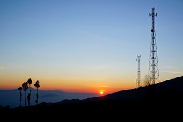 Silhouettes telecommunication tower at sunrise.