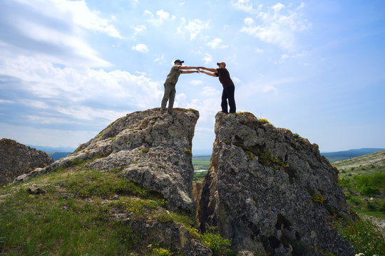 man and a woman standing, her hands outstretched to each other , at split mountain . © amarinchenko106