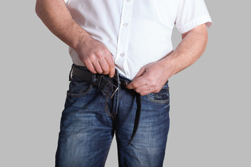 the fat man tries to clasp jeans