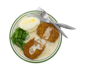 Fried chicken patties TV dinner on plate with silverware
