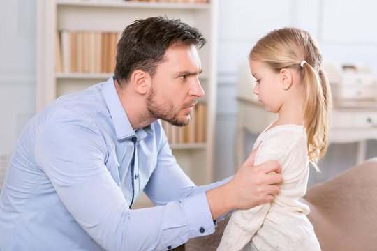 Strict father punishing his daughter 