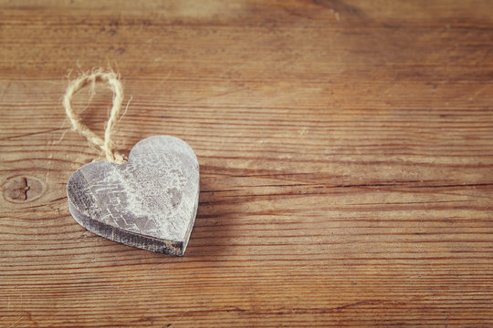 selective focus photo of wooden heart on rustic table.  valentine's day celebration concept. vintage filtered and toned