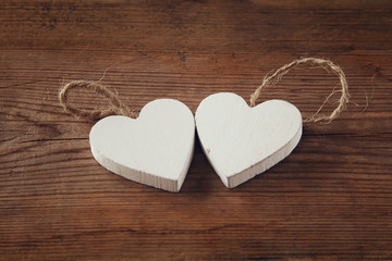 selective focus photo of couple of wooden hearts on rustic table.  valentine's day celebration concept. vintage filtered