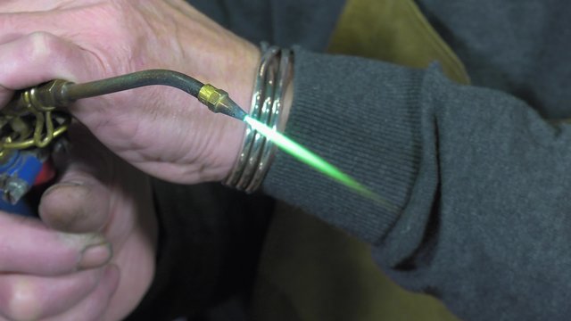 a craftsman jeweler creates a bracelet