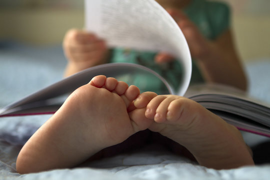 Foot closeup.An image of a toddler reading a book.
