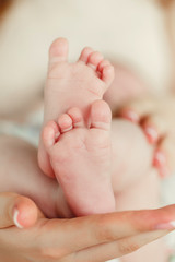 Children's legs on a mother's palm