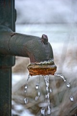 Alter Gusseisen-Wasserhahn am Brunnen
