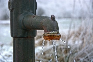 Alter Gusseisen-Wasserhahn am Brunnen