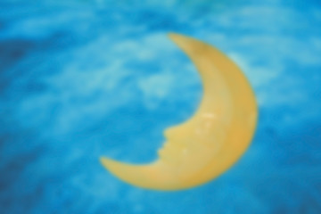 Blurred scene of sleeping moon in blue sky background.