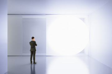 A man stands in an empty white room with copy space