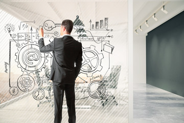 Man draws business plan on a glass partition in the meeting room