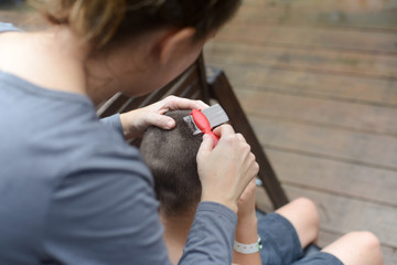 Mother removes lice from son's hair using a fine-tooth comb