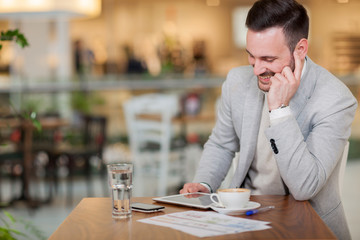  young businessman working on a digital tablet in a cafe