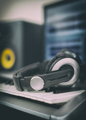 Audio earphones. Home recording studio with professional monitors and midi keyboard.