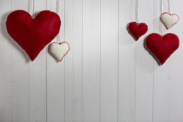 Valentine's Day background / Wooden background with red and white cloth hearts.
