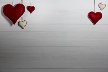 Valentine's Day background / Wooden background with red and white cloth hearts.