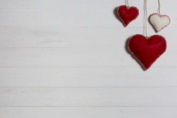 Valentine's Day background / Wooden background with red and white cloth hearts.