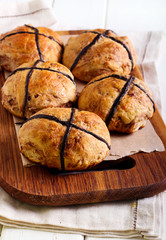 Chocolate hot cross buns on wooden board