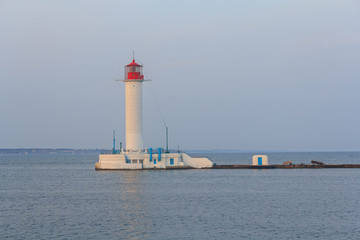 Fototapeta na wymiar White lighthouse, the sea and coastline. Odessa, Ukraine