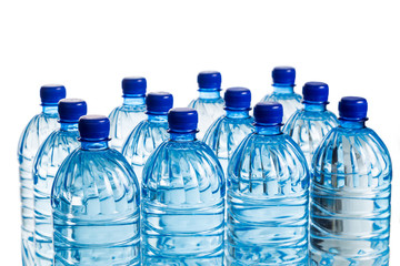 Closeup on rows of refreshing natural mineral water in plastic bottle in white background