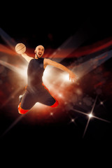 Fototapeta na wymiar Bald baksetball player in the game makes slam dunk with one hand