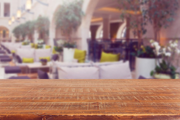 Empty wooden retro table over restaurant interior background