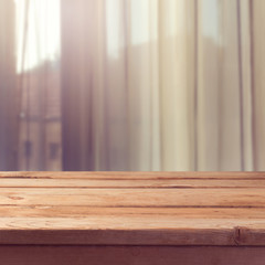 Empty wooden deck table over window curtains background