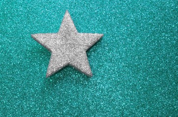 lone silver star on glitter material on cyan shiny  background