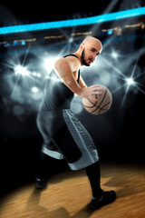 Player in basketball on the floor with ball in hands looking awa - obrazy, fototapety, plakaty