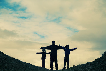 father hiking with two kids