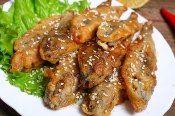 closeup of a plate with spanish boquerones fritos, battered and fried anchovies typical in Spain, on a rustic wooden table